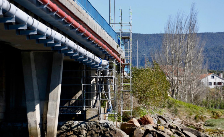 Montan los andamios para iniciar la reparación de la tubería de agua bajo el puente de Castrelo